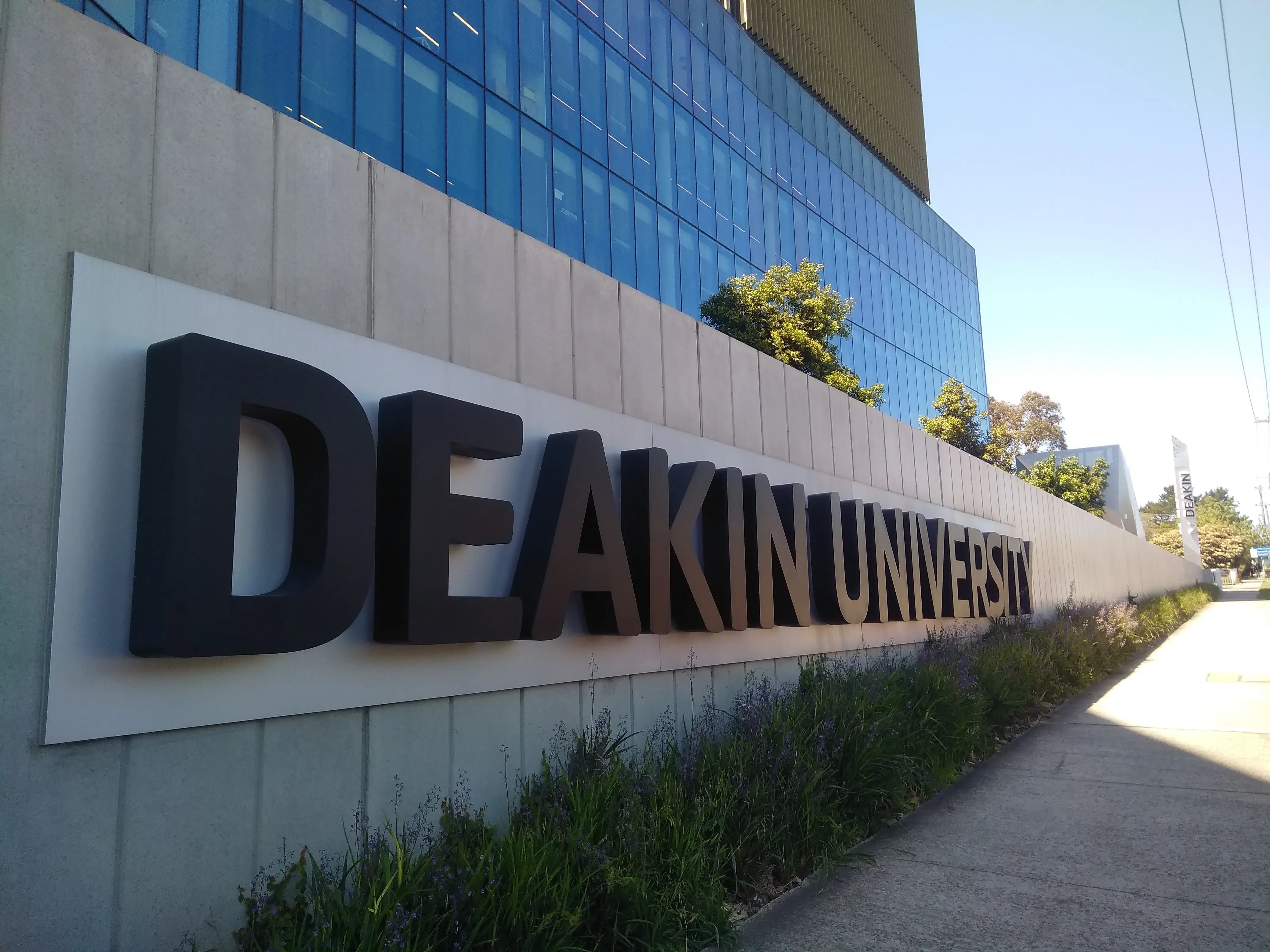 Das moderne Eingangsgebäude der Deakin University mit auffälligem Logo.