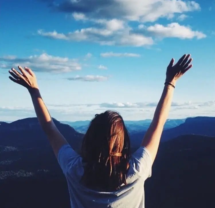 Eine Studentin der University of Newcastle posiert vor vielen Bergen Australiens