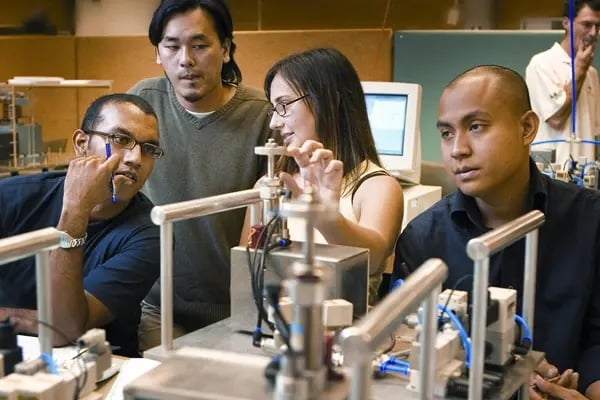 Vier Studierende der University of Newcastle sitzen in der Vorlesung und arbeiten an einem Projekt 