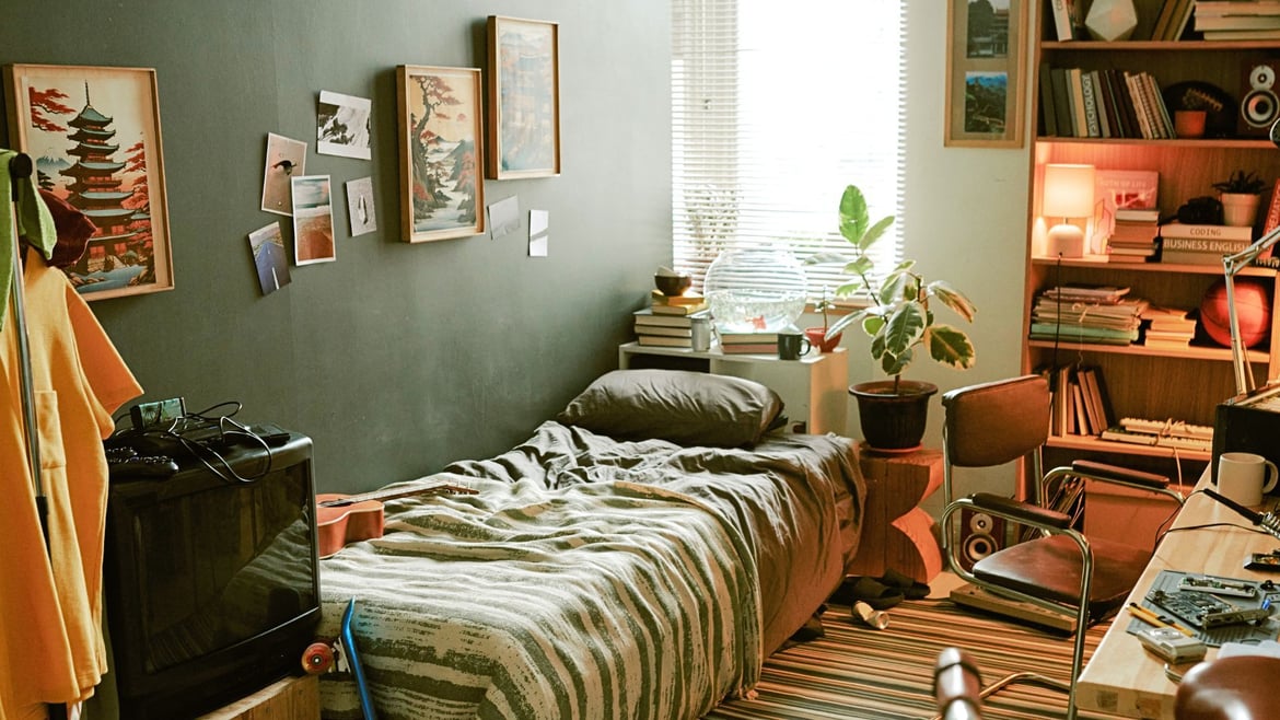 Studentenzimmer im Auslandssemester mit Bett, Schreibtisch, Büchern und persönlichen Dekorationen – gemütliche Unterkunft für internationale Studierende