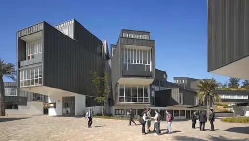 Modernes Gebäude der Universidad Adolfo Ibáñez mit Studierenden vor dem Eingang.