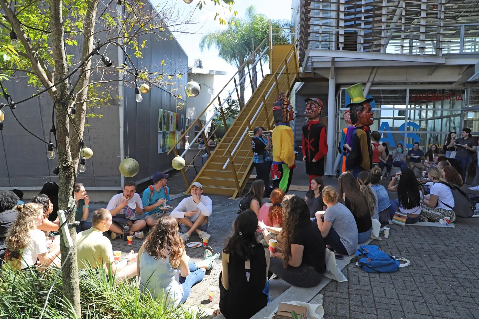 Studierende sitzen versammelt vor dem Campus der Universidad Veritas