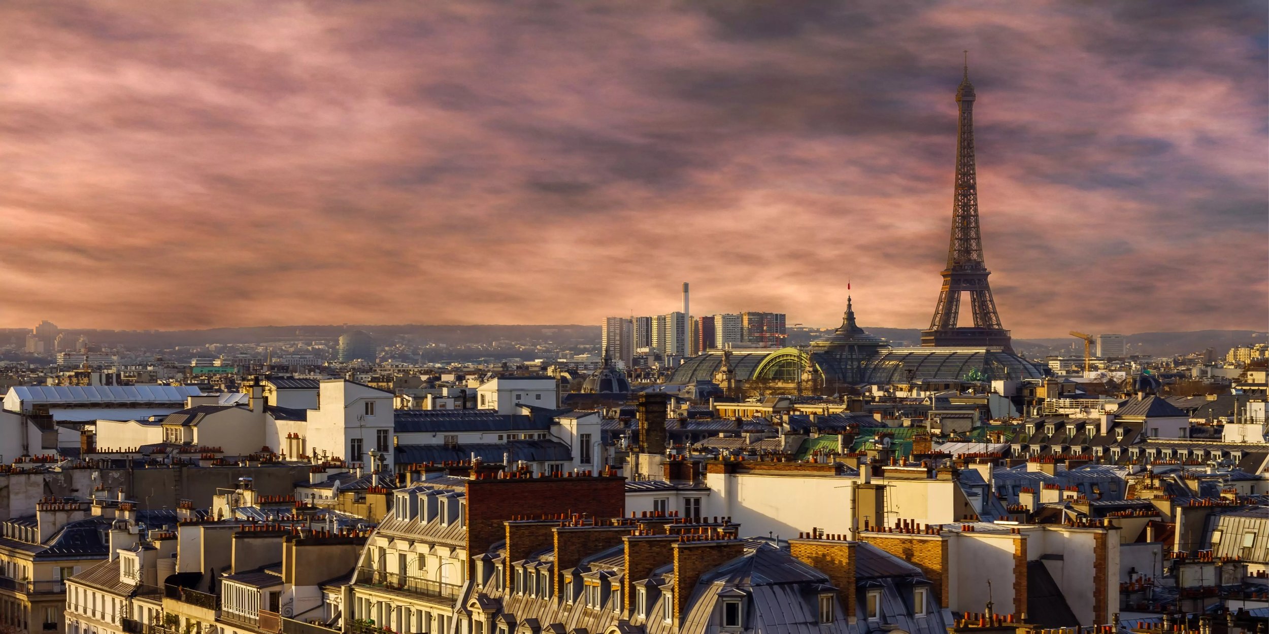 Panoramablick auf Paris mit dem Eiffelturm bei Sonnenuntergang. Historische Dächer und ikonische Sehenswürdigkeiten der französischen Hauptstadt