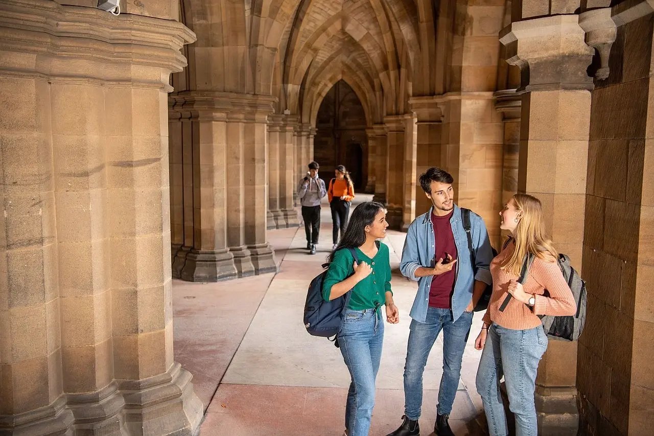 Drei Studierende unterhalten sich im Campus der University of Glasgow