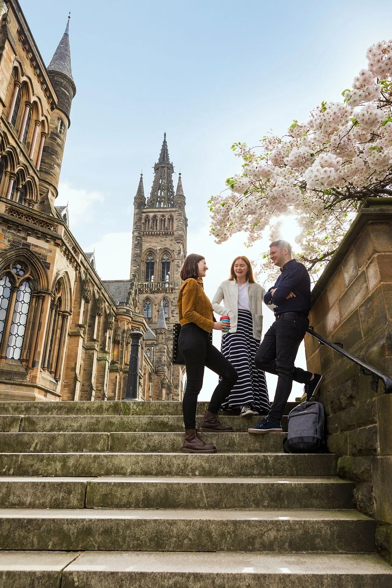 Drei Studierende stehen vor dem Campus der University of Glasgow