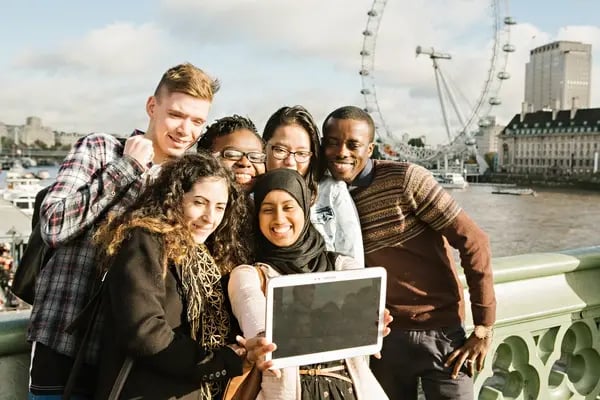 Gruppe von Studierenden der University of Westminster posiert mit Tablet vor Londoner Wahrzeichen