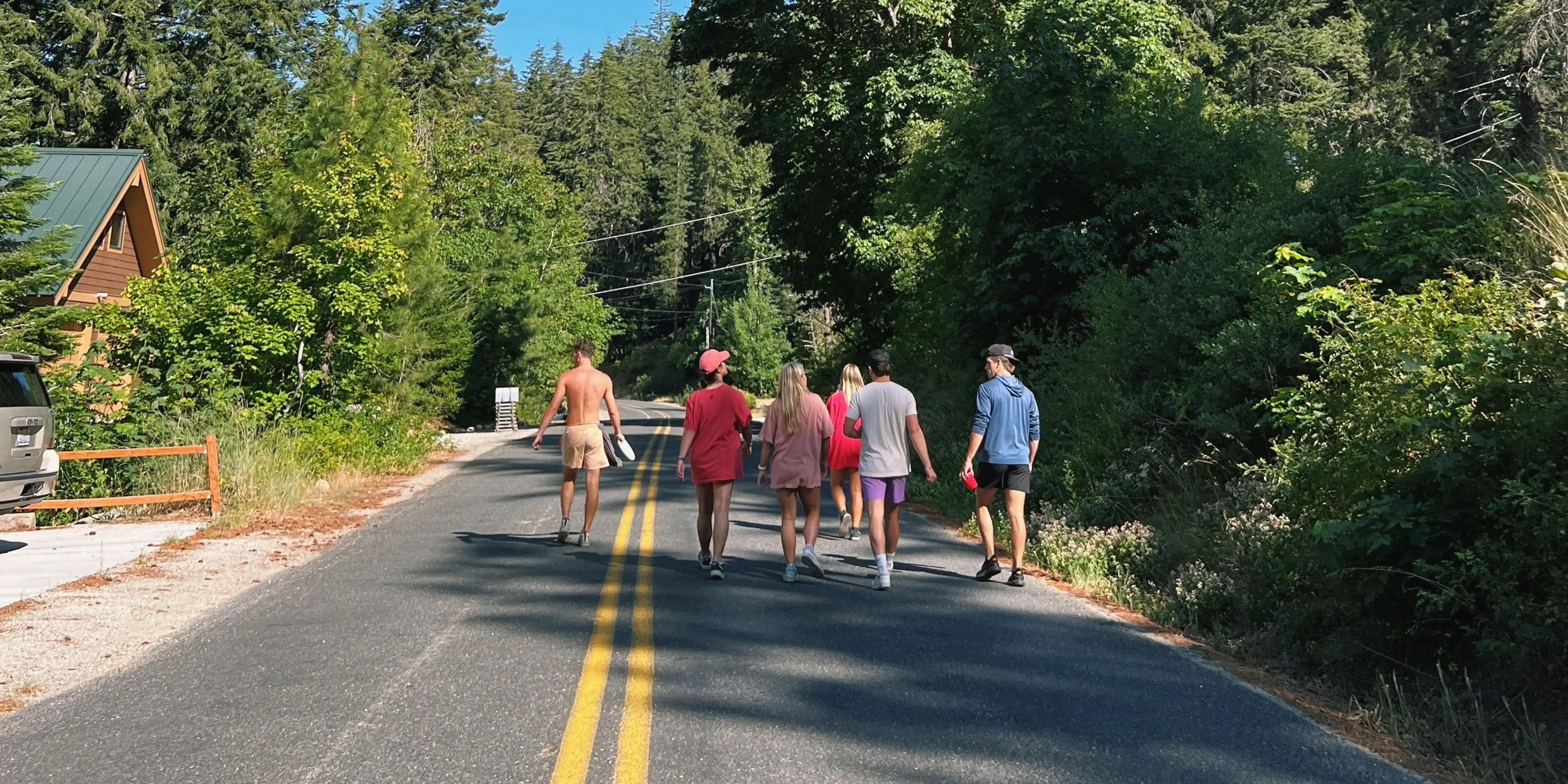 Hubspot LansdcaJugendliche von hinten auf Straße mit Blick auf Mischwald und blauen Himmel. ape Format (20) (1)