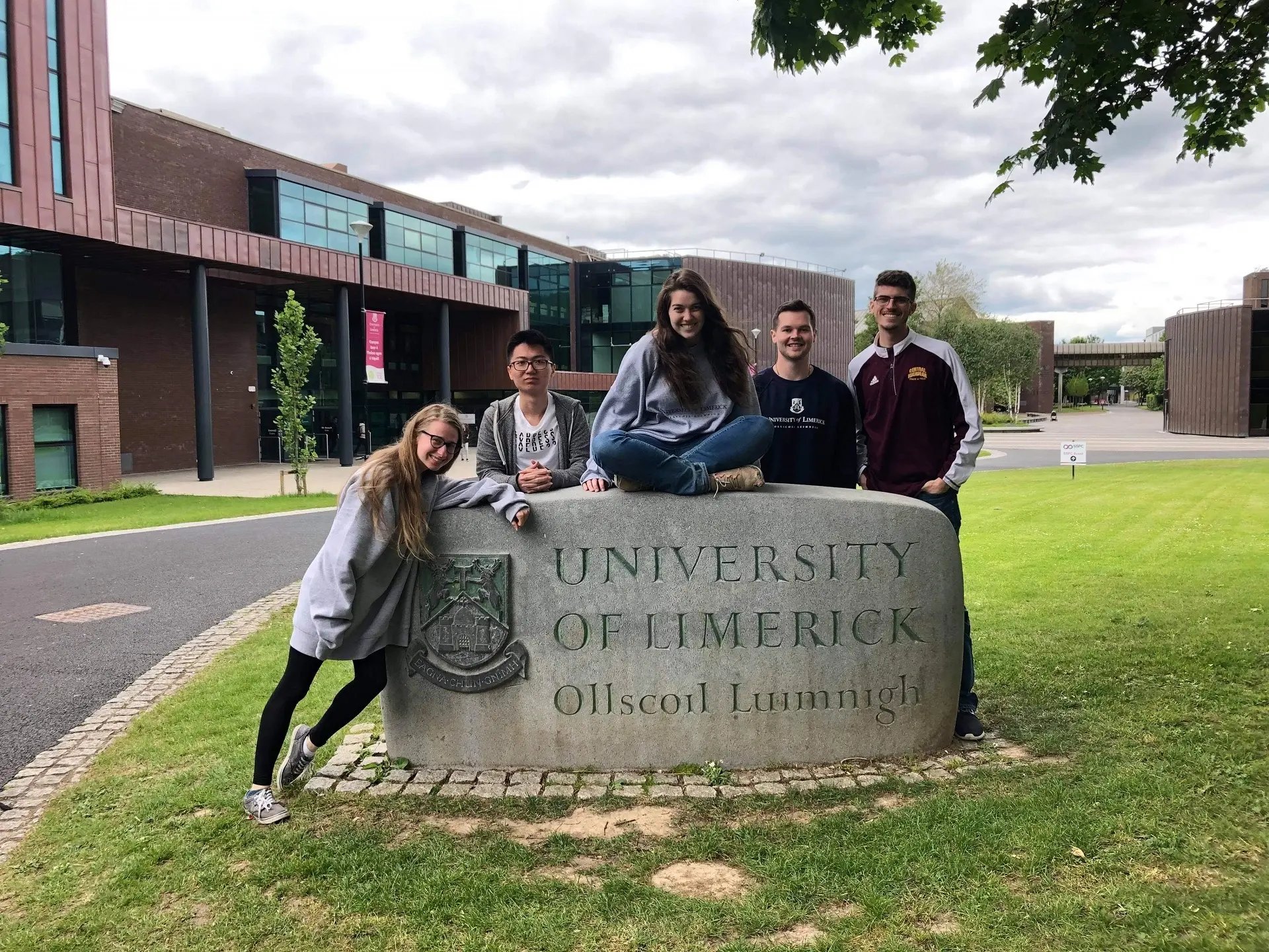 Fünf Studierende posieren am University of Limerick Stein vor dem Gebäude