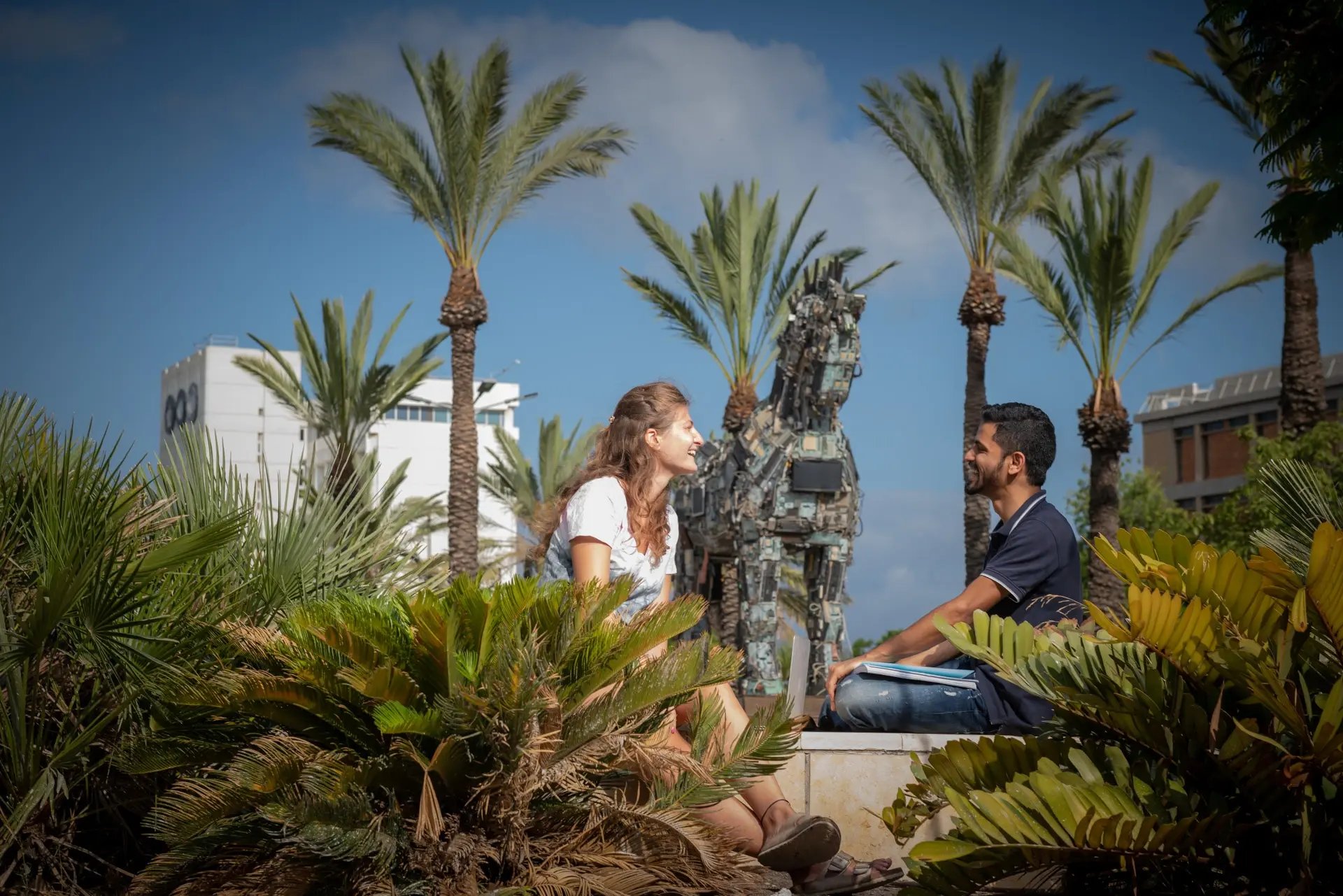 Studierende auf dem Campus der Tel Aviv University mit Palmen