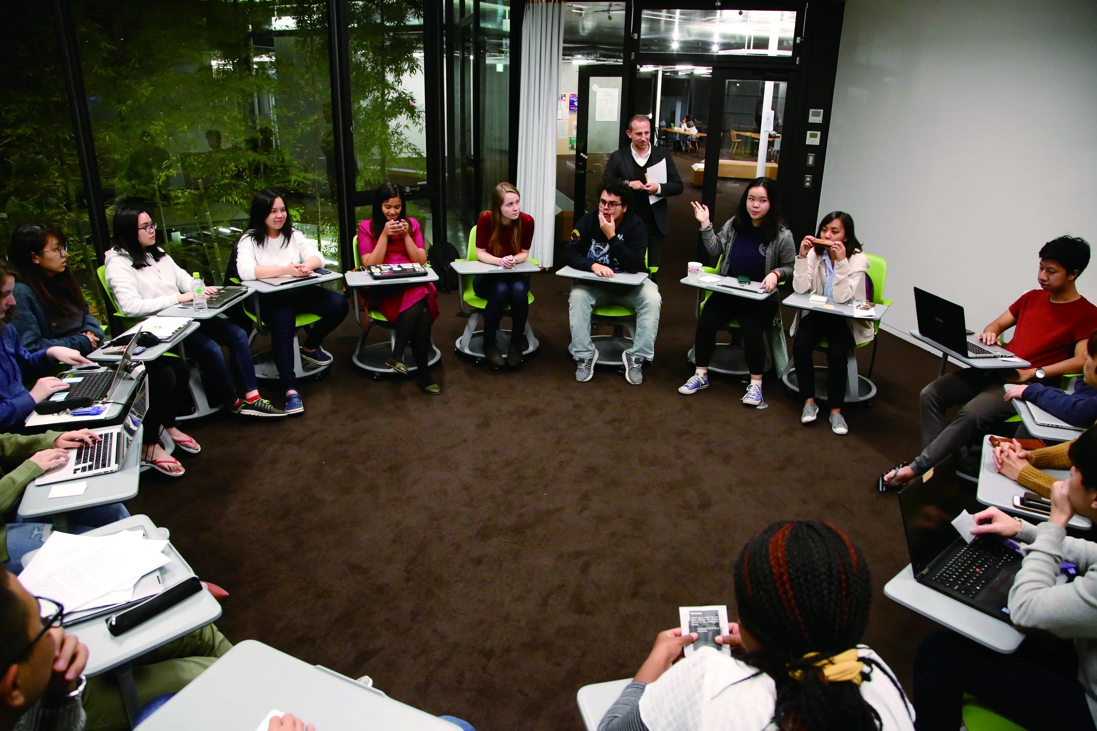 Studierende der Yamanashi Gaukin University sitzen in einem Kreis und lernen.
