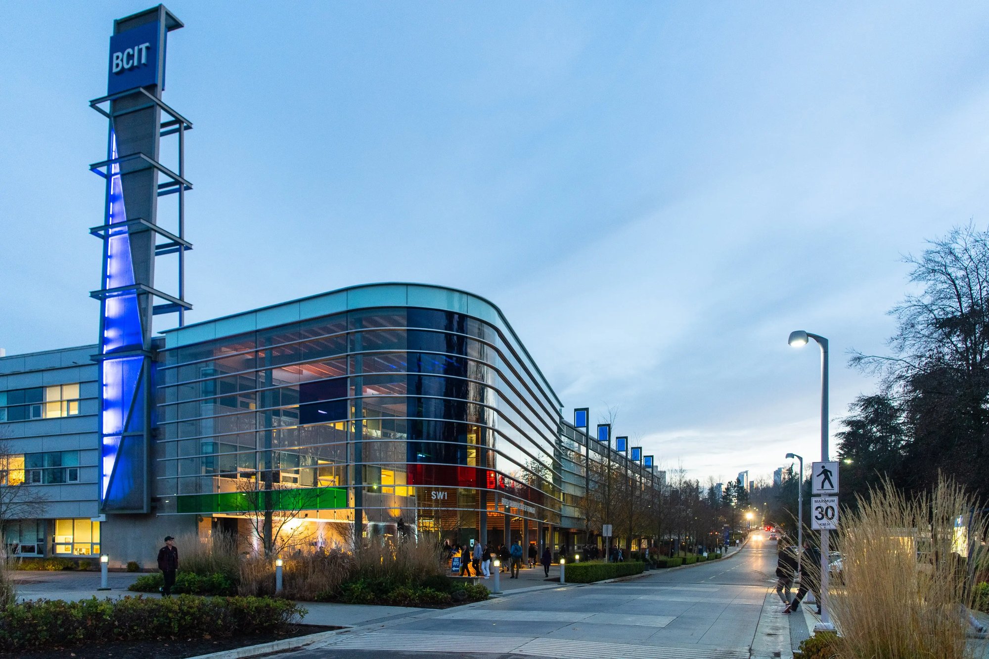 Moderne Glasfassade des British Columbia Institute of Technology mit blauem Himmel.
