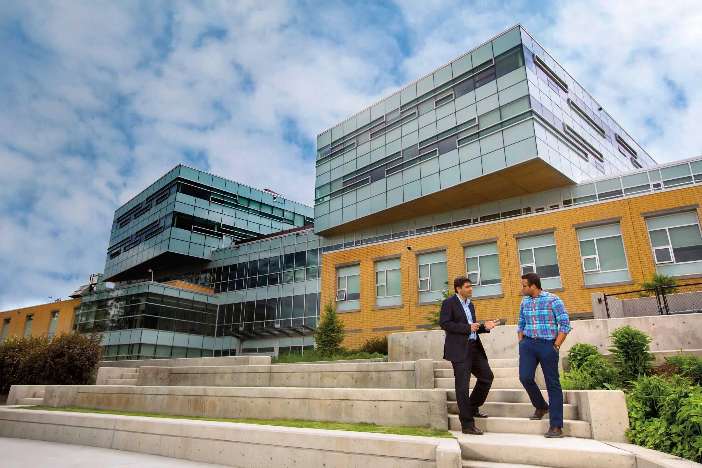 Zwei Personen unterhalten sich auf den Stufen vor dem Campus der University of British Columbia in Vancouver