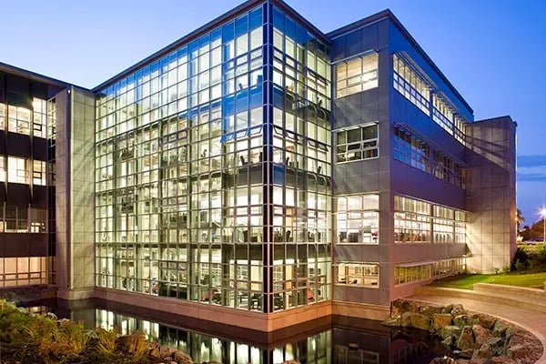 Modernes Universitätsgebäude der University of Victoria bei Abenddämmerung mit Glasfassade