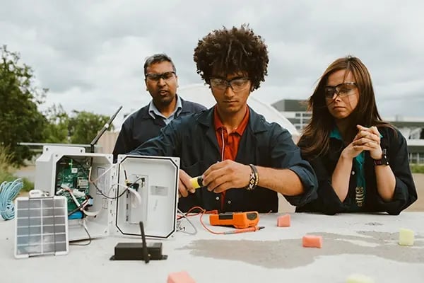 Studierende arbeiten im Freien an technischen Geräten unter Anleitung an der University of Victoria