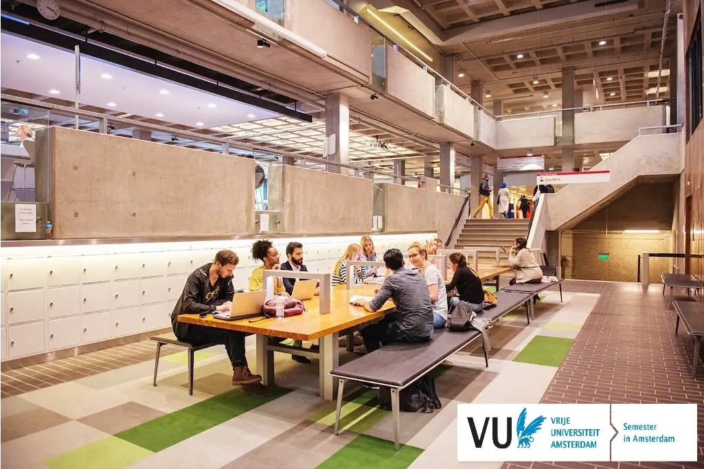 Ein Innenbereich vom Campus der Vrije Universiteit Amsterdam mit Studierenden im Gespräch