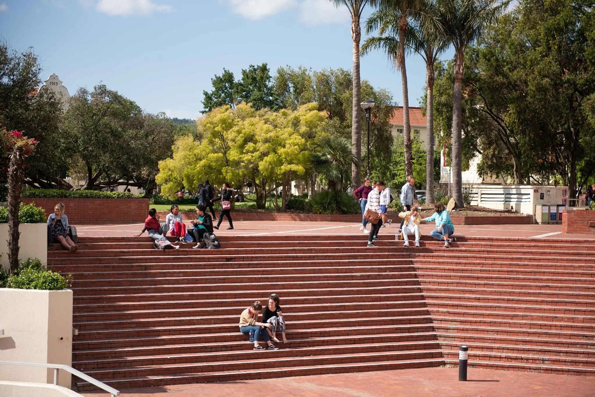 Studierende der Stellenbosch University sitzen auf den Stufen der Stellenbosch University