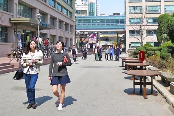 Studierende laufen am Campus der  Hankuk University of Foreign Studies entland