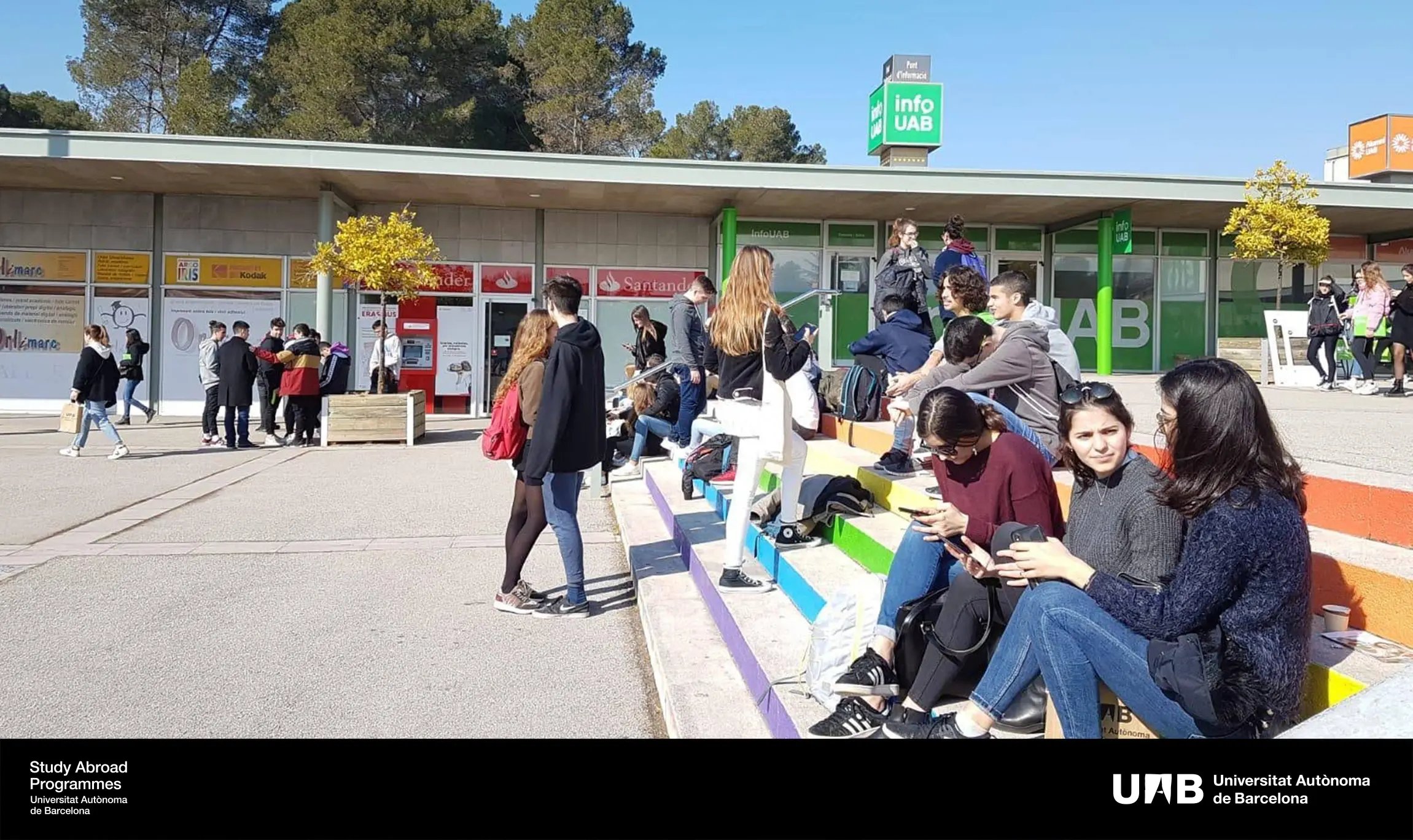 Studierende sitzen auf den Stufen vor dem Campus der Universitat Autònoma de Barcelona