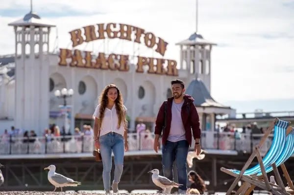 Zwei Personen vor dem Brighton Palace Pier bei sonnigem Wetter