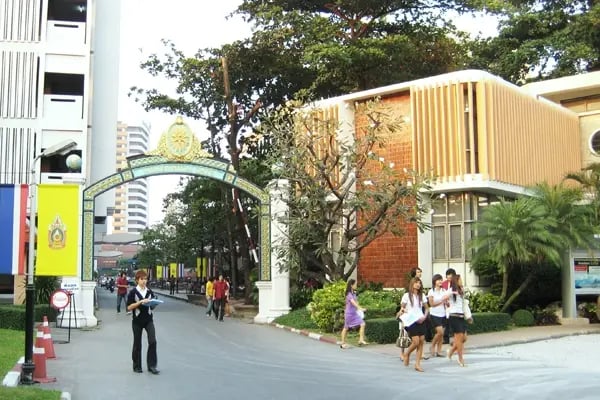 Moderner Campusbereich der Siam University mit Studierenden und begrünten Wegen.